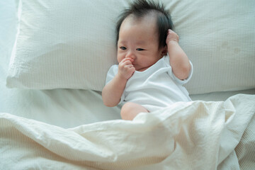 Baby Relaxing on Bed in Soft Morning Light