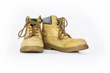 Vintage yellow leather hiking boots with laces in a worn look. Beige used military shoes with thick soles. Isolated on white background. Studio light. Copy space