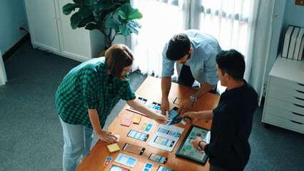 Top view of smart Ui designer brainstorming and planning about Ux Uo design or mobile interface wireframe design with diverse develop team. Caucasian programer walking and joining meeting.Convocation.