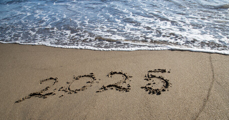Fototapeta premium tropical New Year 2025 written in sand on the beach