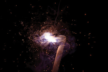 A bright flash of light and a sheaf of sparks in a cloud of smoke. Miniature Universe. Design...