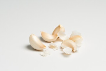 Peeled garlic cloves on a plain background