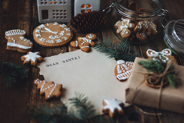 Christmas written letter with wish list with Dear Santa text. Xmas December tradition for kids and adults, cozy home decor, homemade gingerbread cookies, new year decoration, wooden rustic background