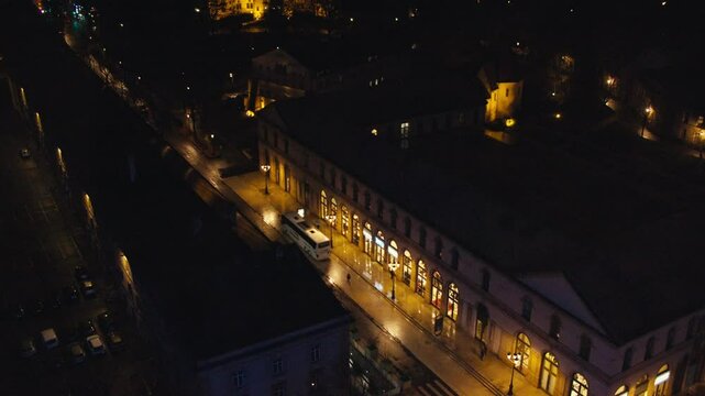 Aerial shot of Arsenal of Metz by night. During Christmas Market. Sentier des lanternes Metz. Camera tilt and sees horizon. People walking by. Miniature world style. Late night walk. Moselle.