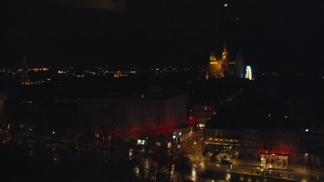 Aerial shot of Centre of Metz by night. Cathedral Saint Etienne visible in the background. Ferris Wheel Illuminated. Red Market. Garbage truck pass by.