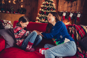 Photo of two peaceful people mother daughter sit couch play laugh new year xmas garland lights...