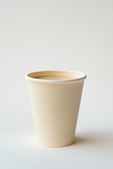 Disposable paper cup filled with warm beverage on plain background