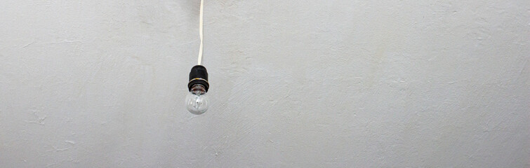 a lonely light bulb on the ceiling hanging on one wire, a place for copy space