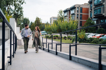 Two business people walking and talking on their coffee break