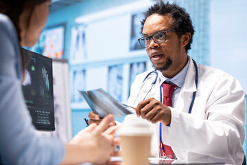 Male physician doing an x ray diagnostics scan interpretation during check up visit, discussing...