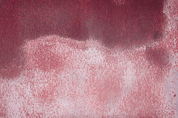 Fragment of a rusty grunge surface. Dark red background color. Scuffs and peeling of old paint....