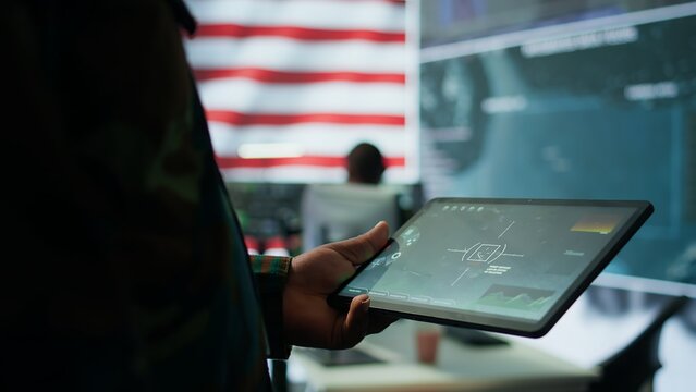 Military personnel in high tech environment safeguard classified information, monitor cybersecurity threats and digital warfare operations to protect against attacks and data breaches. Camera B.