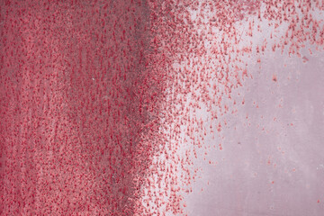 Fragment of a rusty grunge surface. Dark red background color. Scuffs and peeling of old paint....