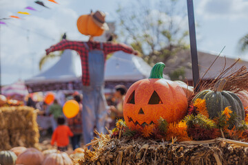 Halloween pumpkin with a scarecrow in the background in a family-friendly atmosphere, captured in the afternoon, creating a spooky and festive vibe.