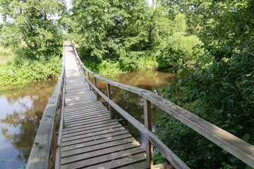 Obraz premium a suspension bridge over the river on an autumn day. The background is blurred, yellow foliage