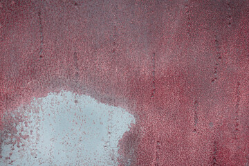 Fragment of a rusty grunge surface. Dark red background color. Scuffs and peeling of old paint....