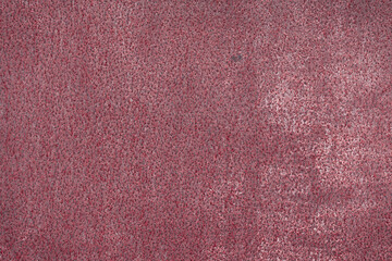 Fragment of a rusty grunge surface. Dark red background color. Scuffs and peeling of old paint....