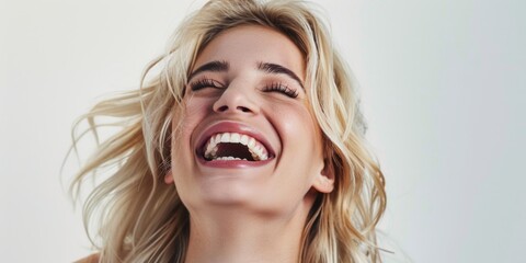Young woman laughing with joy and a bright smile.