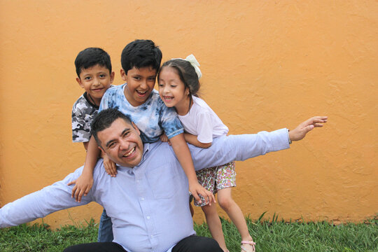 Single Dad with two brown latino sons and daughter spend time together and have fun to celebrate Father's Day in poverty
