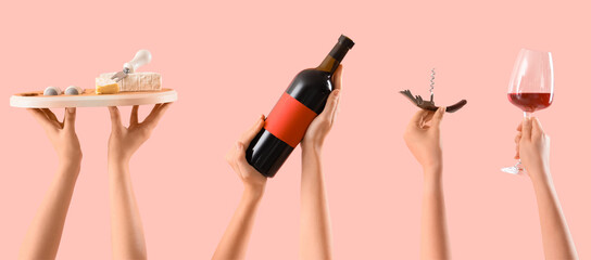 Female hands holding bottle of wine, cheese and corkscrew on pink background