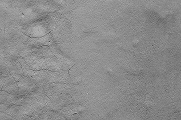 Monochrome texture of a concrete wall with natural relief and damage in the form of chips and...