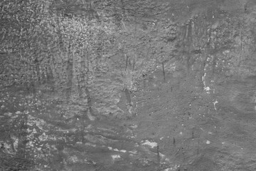 Monochrome texture of a concrete wall with natural relief and damage in the form of chips and...