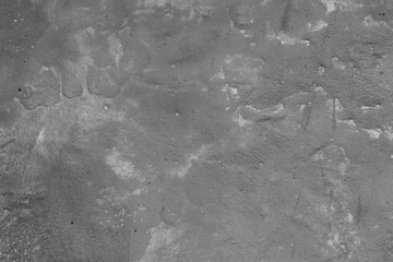 Monochrome texture of a concrete wall with natural relief and damage in the form of chips and scratches. Fragment of an old stone surface with a crack. Dark rough surface with a place for an inscripti