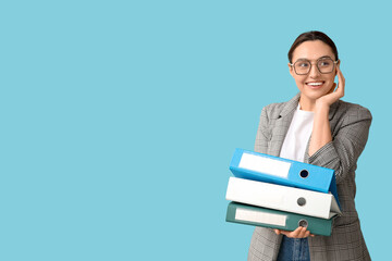 Young businesswoman in eyeglasses with document folders on blue background