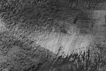 Monochrome texture of a concrete wall with natural relief and damage in the form of chips and...