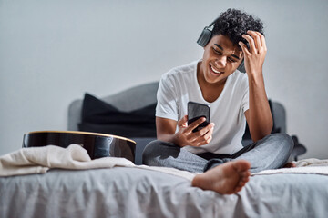 Phone, happy man and listening to music in bedroom, audio and sound to relax in home. Mobile, bed...