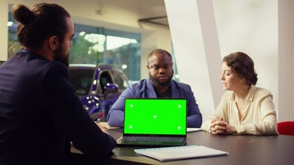 Dealership salesman looking over appointment list on chroma key laptop spreadsheet to schedule car test drive. Showroom agent arranging meeting with clients using isolated screen notebook, camera B