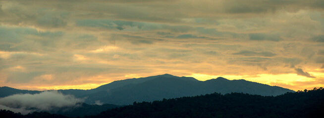 Obraz premium Banner Beautiful Mountain landscape foggy mountain green landscape morning sunrise. Amazing Landscape mountain green tropical forest tree on sunrise. Banner forest sunlight scenery with copy space