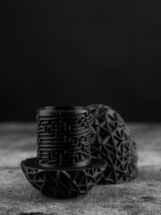 Close-up of a plastic egg model with ornament on a black background