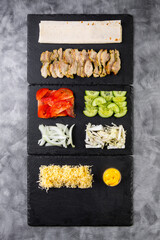 Close-up of the process of making shawarma: tomatoes, onions, cabbage, cucumbers and sliced...