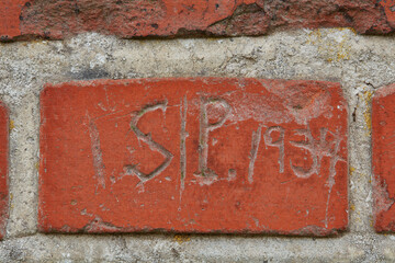 Scratch, writing and word on brick wall of building in city for background, pattern and exterior design. Construction, architecture and closeup of graffiti or texture on stone, concrete and cement