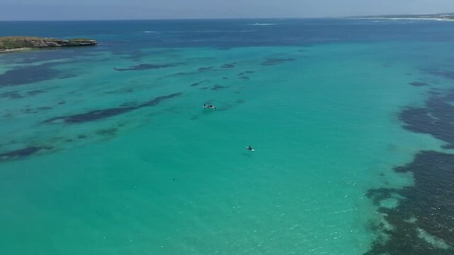 Aerial reveal of Lancelin Island on a perfect summer day with calm turquoise waters.