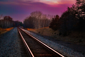 Fototapeta premium abstract railway at sunset with shiny metal track perspective background