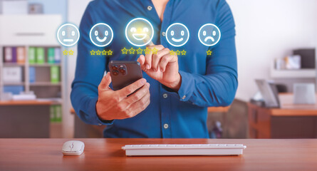 Customer Service Feedback. User rating a satisfactory customer service survey on mobile device in modern office. Concept of customer satisfaction and service quality evaluation