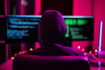 Black Hat Hacker hoodie concept at a laptop computer hacking the Internet. Cyber crime and security principles.
