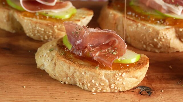 Spanish tapas of Serrano ham, apple and jam, checkered table background, macro view