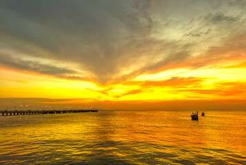 landscape,The beautiful yellow sky in the evening after sunset reflects the  sea and the bridge.