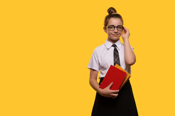 Teen girl adjusting glasses, holding books, wearing school uniform, confident expression