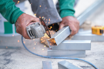 Using a Abrasive Cutoff Machine or chop saw on the floor to cut a piece of steel square tube.