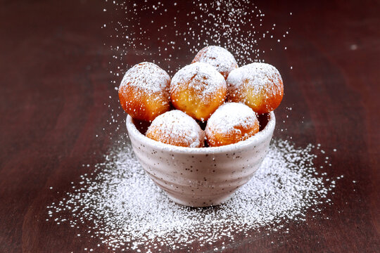 Sprinkle with sugar powder munchkins cooked homemade on blue dish.