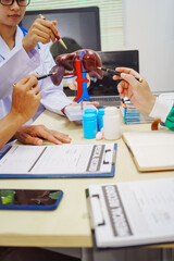 Doctors gather at a hospital desk to discuss treatment plans for liver diseases like hepatitis B,...
