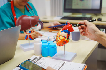 Three doctors meet at hospital desks, discussing cardio-liver disease complexities,including...