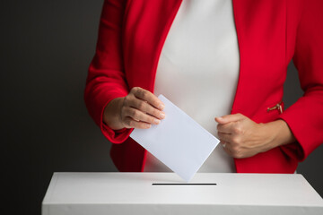 The voter holds his vote ballot paper and places it in the ballot box. Election concept.