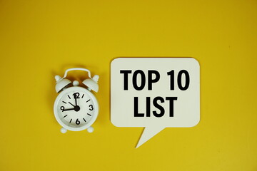Top 10 list text on speech bubble with magnifying glass top view on yellow background