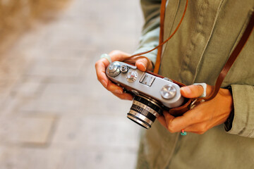 girl with a camera. the photographer adjusts the camera. Stylish girl with a film camera. film...