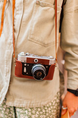 Close-up of a film camera. young girl in stylish clothes. Traveler, travel blogger and social media...